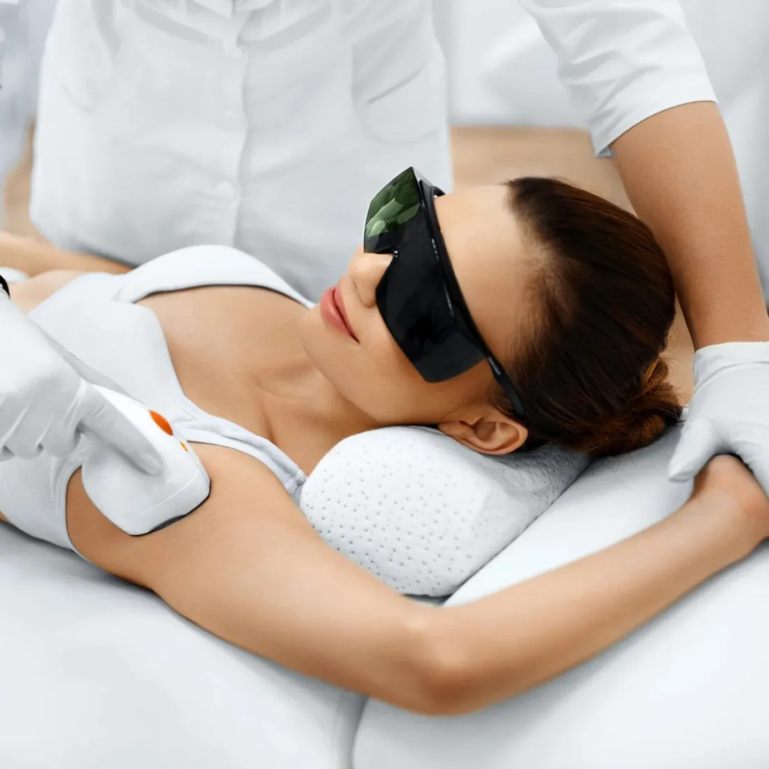 Woman receiving laser hair removal treatment wearing protective eyewear
